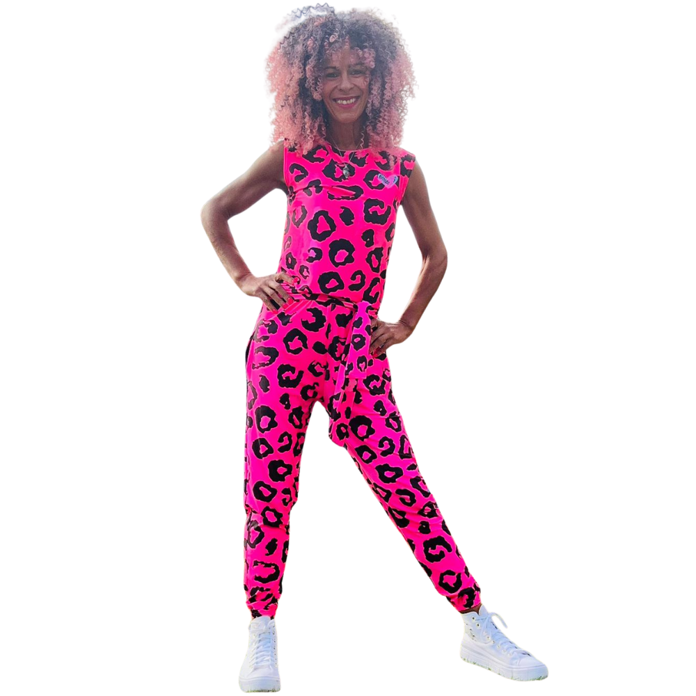 Person wearing a bright pink leopard print jumpsuit on a white background