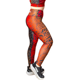 Person wearing red and orange patterned leggings on a white background