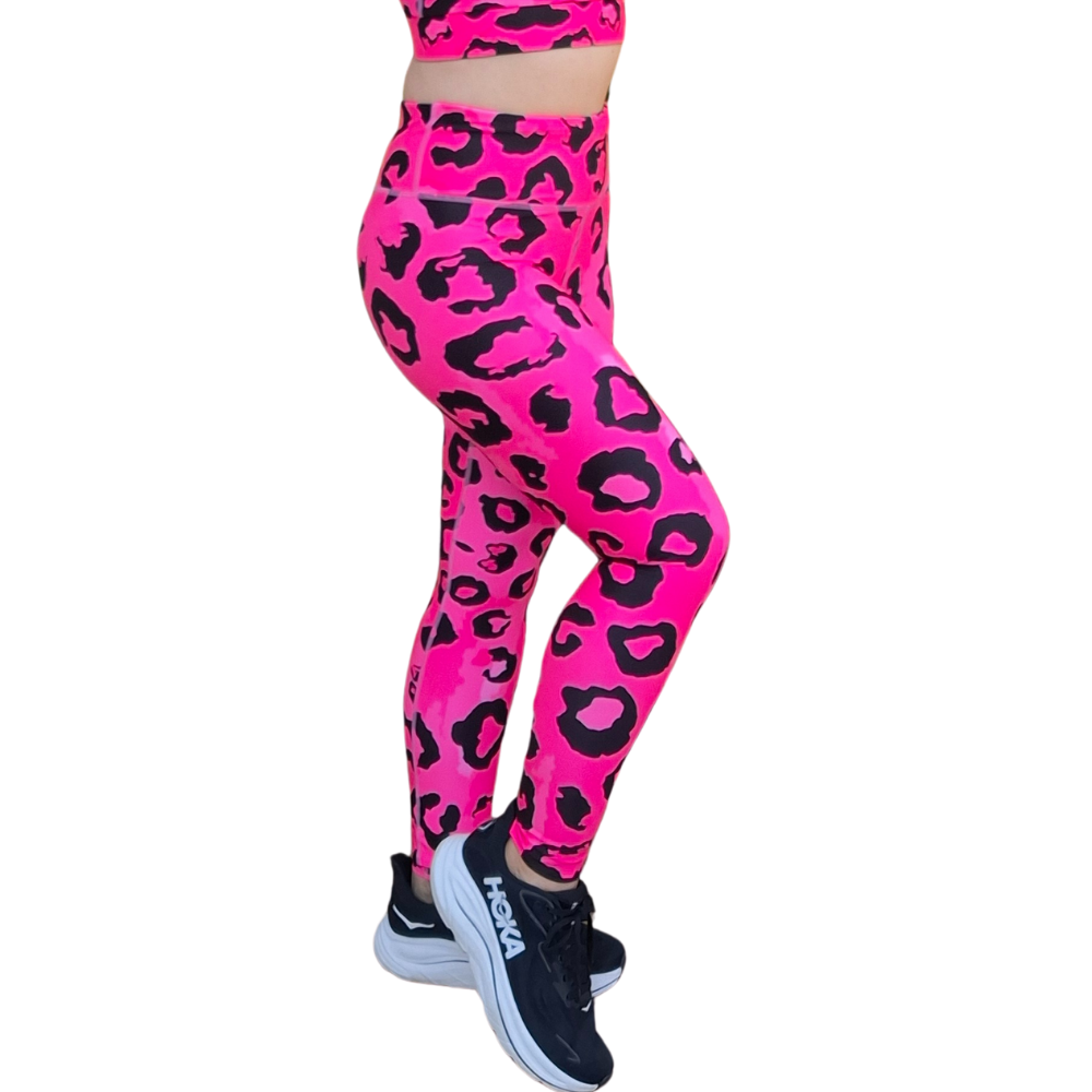 Neon Pink leopard print leggings worn by a person on a white background