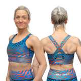 Woman wearing a blue and orange sports bra and shorts set with 'Wild Legs' branding.