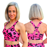 woman wearing pink and black leopard print sports bra, showing front and back view with Wild Legs branding