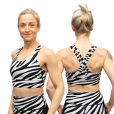 Woman wearing a black and white zebra-striped sports bra and shorts set, shown from front and back.