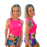 Woman wearing a pink tank top and colorful leggings on a white background