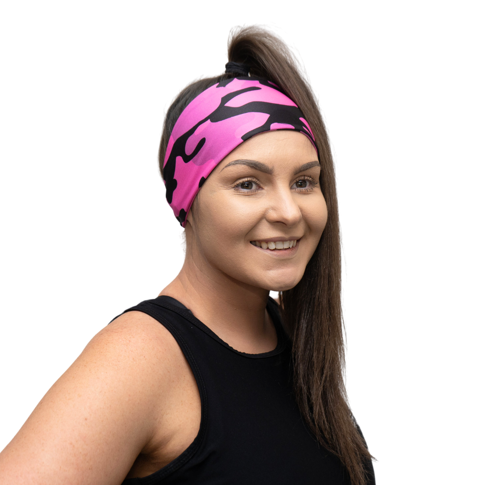 woman wearing a pink and black camo design headband on a white background