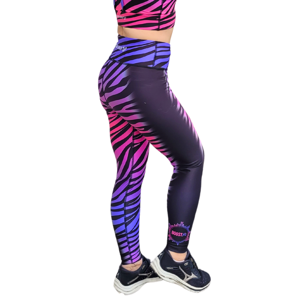 Purple and pink zebra pattern leggings worn by a person on a white background
