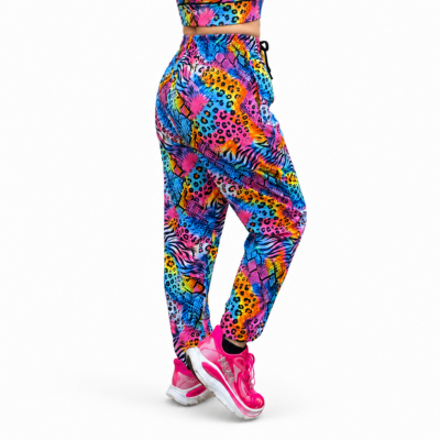 A person shown from the back wearing bright multicolour patterned jogger-style leggings and matching athletic top, with pink trainers, against a plain white studio background.