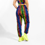 Person wearing a colorful animal print outfit with neon shoes on a white background