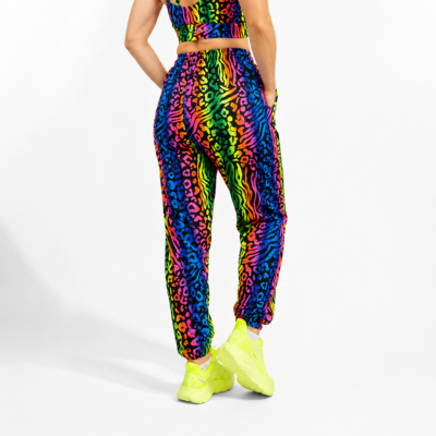Person wearing a colorful animal print outfit with neon shoes on a white background
