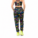 Person wearing a black sports bra and pants with colorful text and graphics on a white background