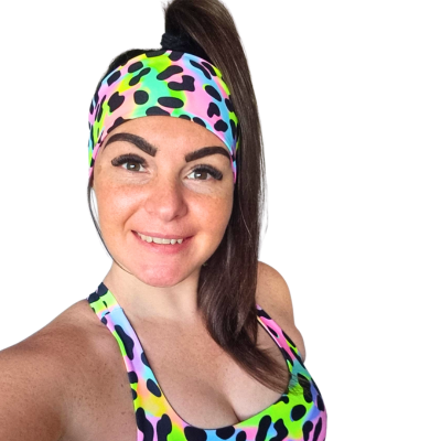 Woman wearing a colorful leopard print headband and sports bra on a white background