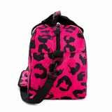 Pink with black leopard print pattern holdall from the side view on a white background