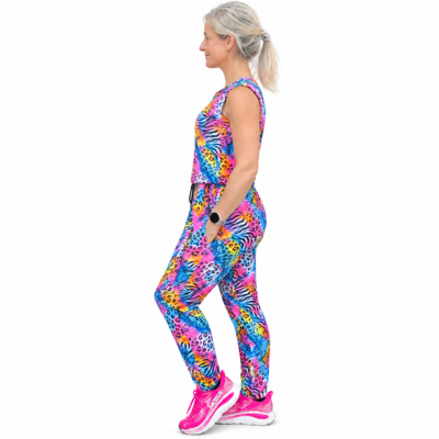 A woman in profile wearing a sleeveless athletic jumpsuit with a bright multicolour animal print, paired with pink trainers, against a plain white background.