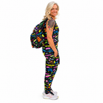 A woman modelling a matching black activewear set with a colourful graffiti-style print, including a jumpsuit, and a backpack, set against a plain white background.