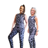 two women wearing grey and black leopard print jumpsuits on a white background