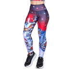 A person modelling high-waisted Christmas leggings with a winter village and starry sky print, paired with black shoes, shown against a plain white background.