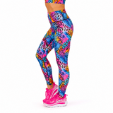 A person wearing bright multicolor patterned leggings and pink running shoes, shown from the waist down against a plain white background.