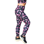 Person wearing black leggings with a pink ribbon design on a white background