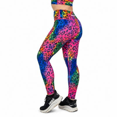 A person wearing bright neon rainbow leopard-print leggings and a matching crop top, shown from the waist down against a plain white background.