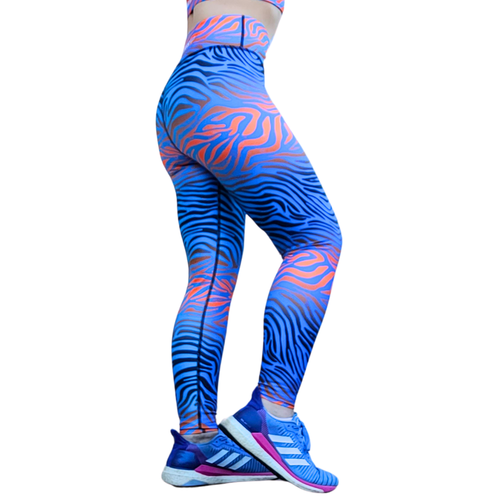 Blue and flaming orange tiger pattern leggings worn by a person on a white background