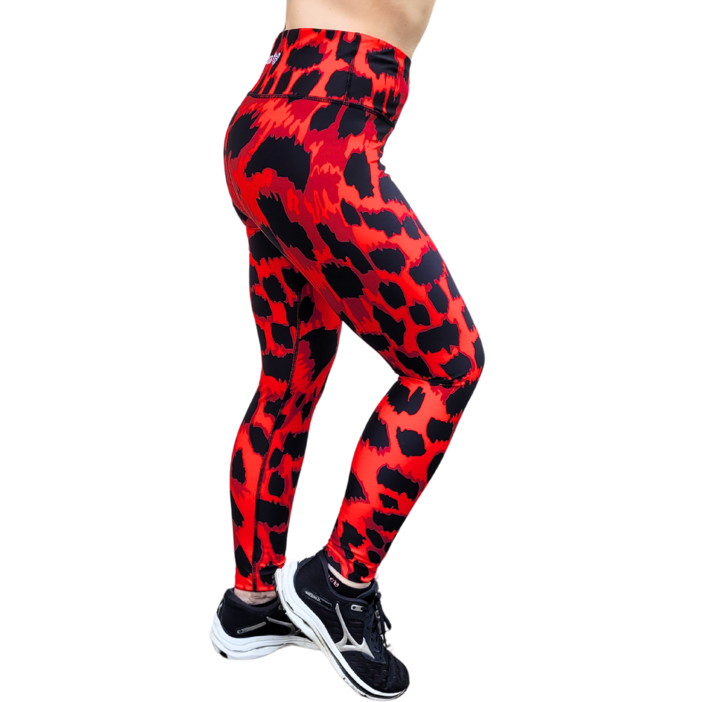 Red and black leopard print patterned leggings worn by a person on a white background
