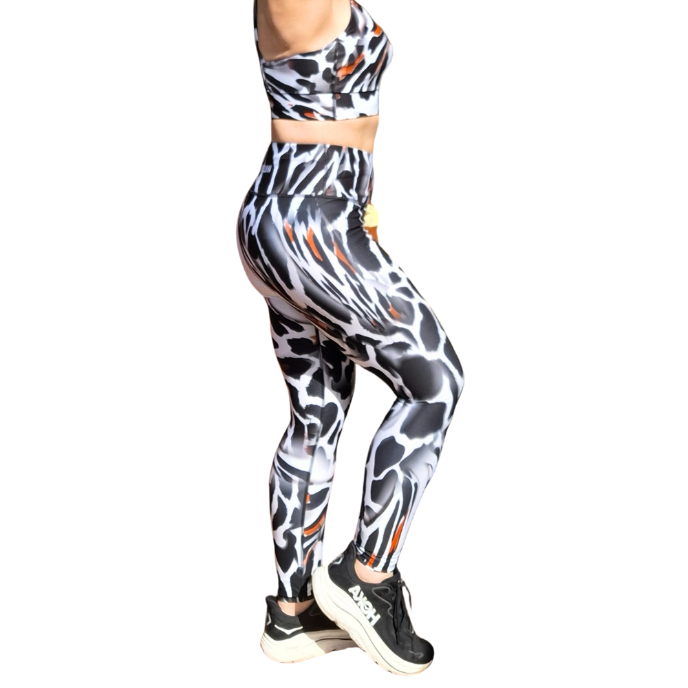 Woman wearing a patterned sports bra and leggings set on a white background