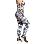 Woman wearing a patterned sports bra and leggings set on a white background