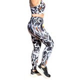 Woman wearing a patterned sports bra and leggings set on a white background