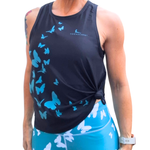 Person wearing a black tank top with blue butterfly patterns and blue leggings with white butterfly patterns.