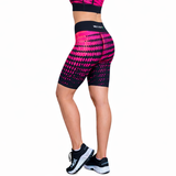 women in black and hot pink fitness shorts with a matching top and black trainers on a white background