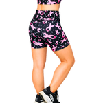 Black shorts with pink ribbon pattern worn by a person on a white background