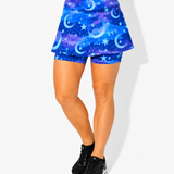 Person wearing a blue galaxy-patterned skort on a white background