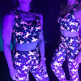 Person wearing a glowing outfit with ribbons and stars pattern in a dark setting