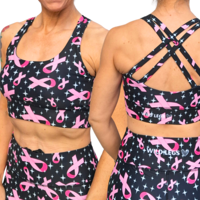 Black sports bra and shorts with pink ribbon pattern worn by a person.