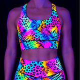 Neon animal print sports bra on a model under UV light