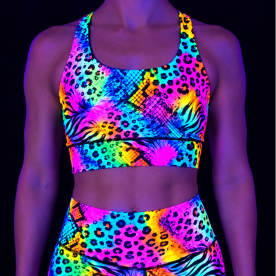 Neon animal print sports bra on a model under UV light