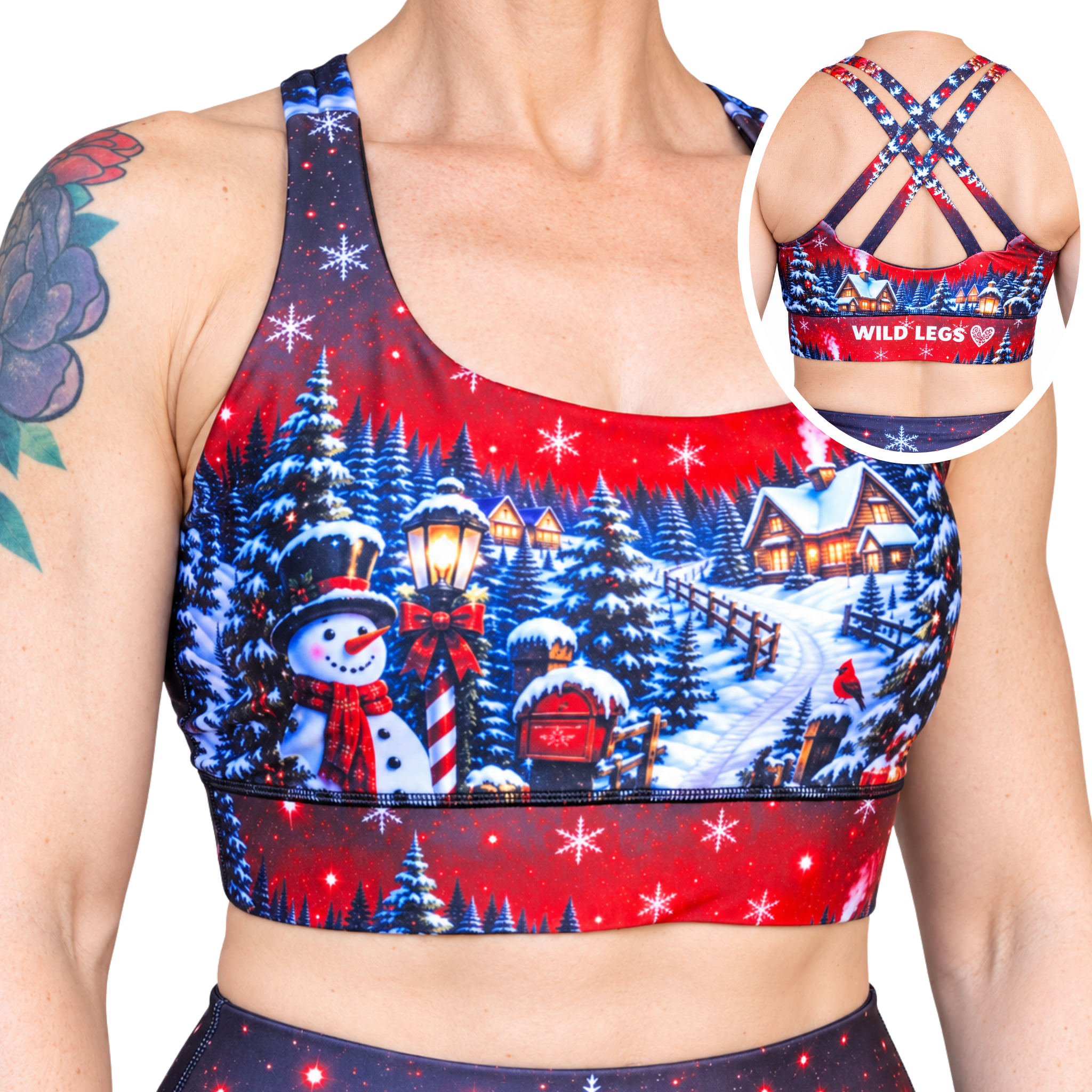 A woman wearing a red and navy Christmas-themed sports bra with a winter village print, featuring an inset circle showing the back straps and the brand name 'WILD LEGS'.