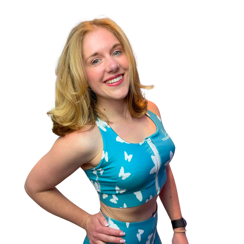 Woman wearing a blue sports bra with white butterfly patterns on a white background