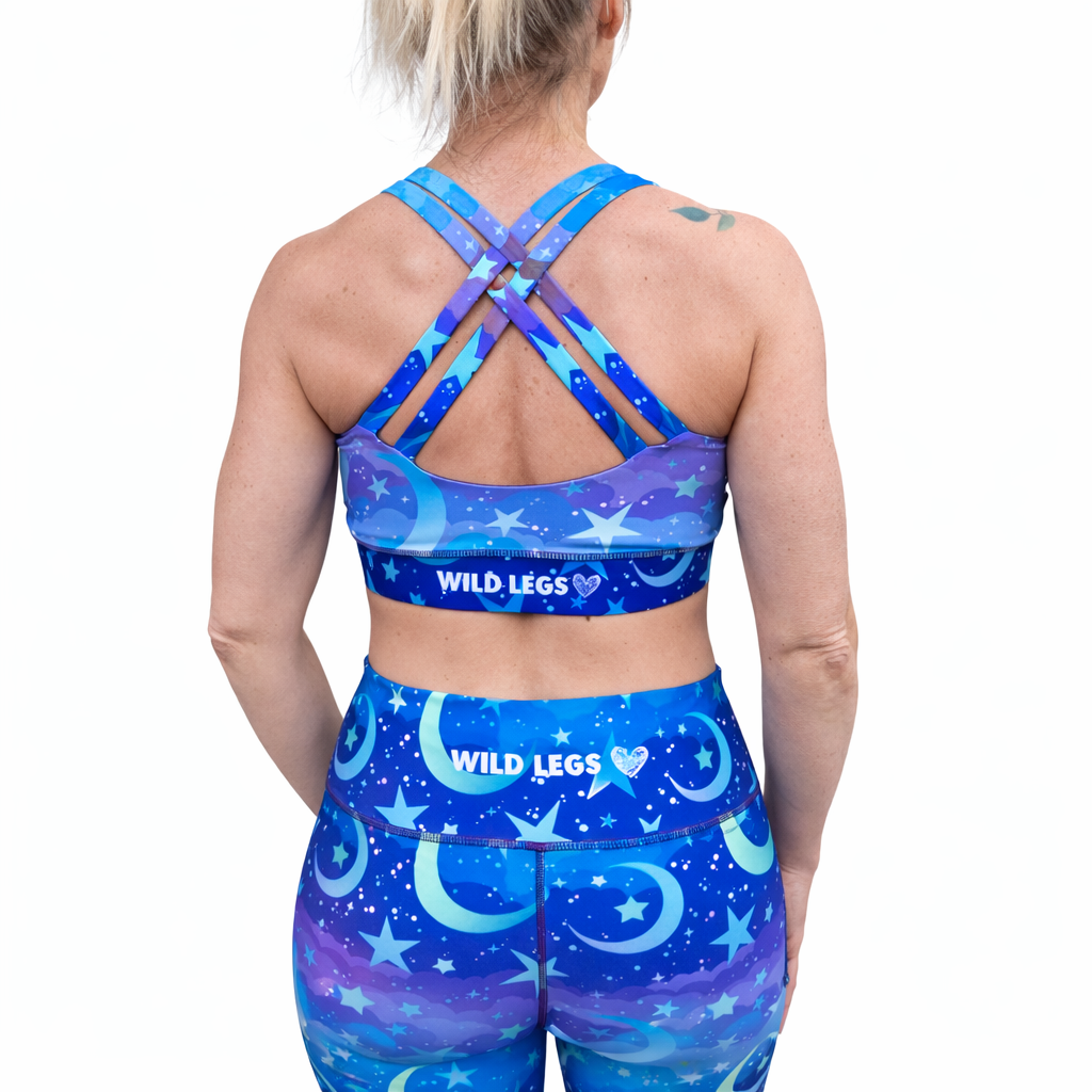 Person wearing a blue sports bra and leggings set with 'Wild Legs' branding on a white background