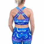 Person wearing a blue sports bra and leggings set with 'Wild Legs' branding on a white background