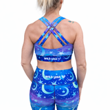 Person wearing a blue sports bra and leggings set with 'Wild Legs' branding on a white background