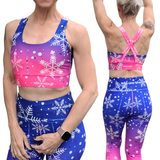 woman wearing bright pink and blue snowflake sports bra and leggings on a white background showing front and back view