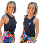 Two women wearing black tank tops and colorful tie-dye leggings on a white background