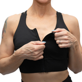 Person wearing a black sports bra with a white background