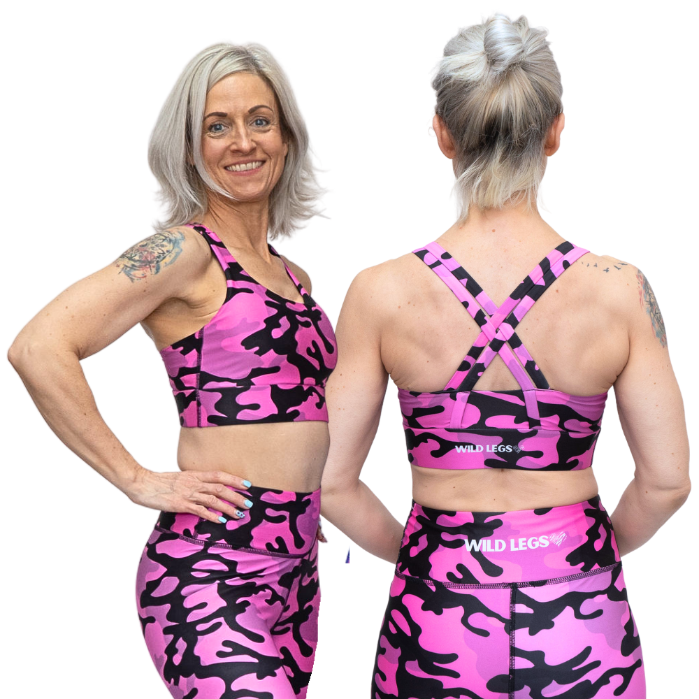 Woman wearing pink and black camouflage sports bra and leggings with 'Wild Legs' branding.