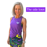 Woman wearing a purple tank top with a side knot, standing against a white background.