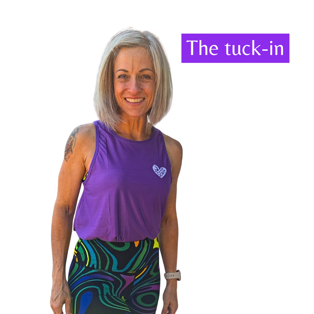 Woman wearing a purple sleeveless top and colorful leggings with text 'The tuck-in' on a white background